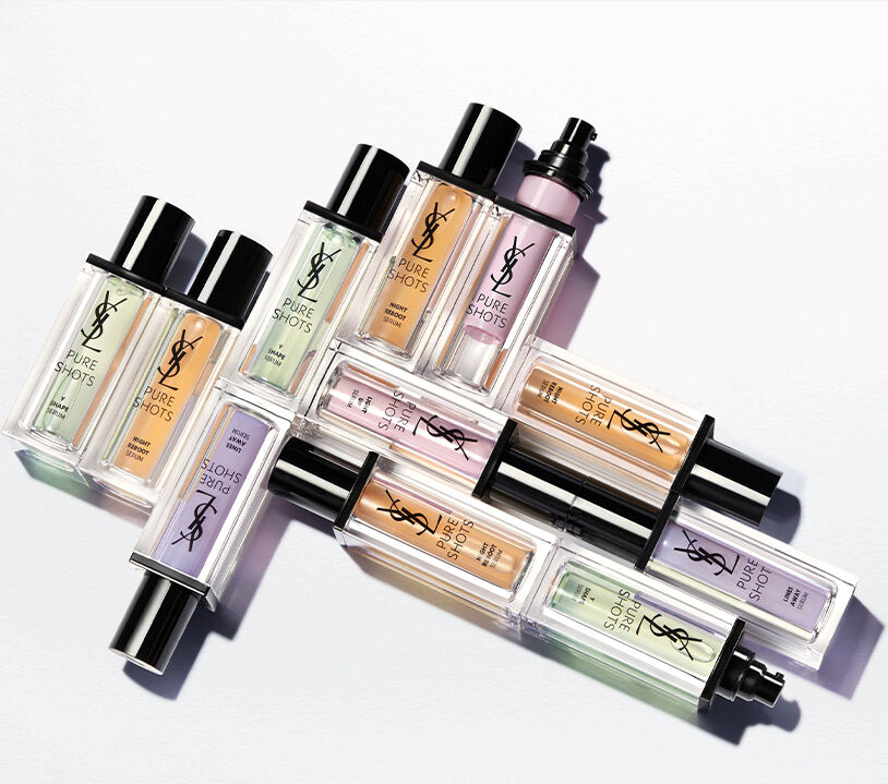 A collection of brightly colored skincare products in sleek bottles, arranged at an angle against a white background.