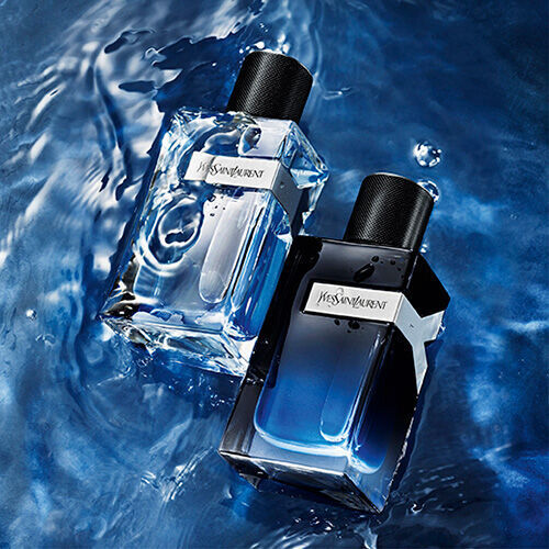 Two stylish perfume bottles resting on a shimmering blue water surface, one clear and the other dark, both showcasing a modern design.