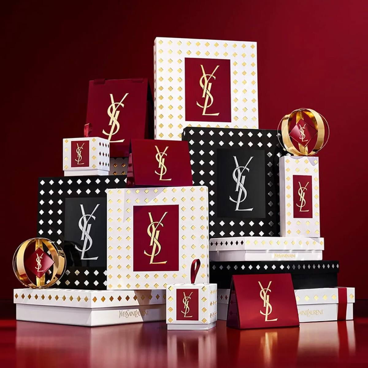 Yves Saint Laurent Weihnachtskollektion-Geschenksets und Luxus-Beautyprodukte vor festlich rotem Hintergrund.