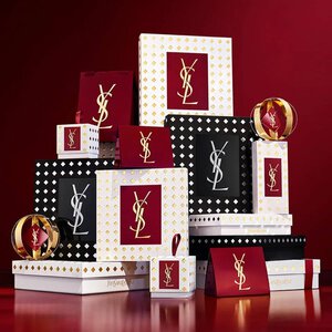 Yves Saint Laurent Weihnachtskollektion-Geschenksets und Luxus-Beautyprodukte vor festlich rotem Hintergrund.