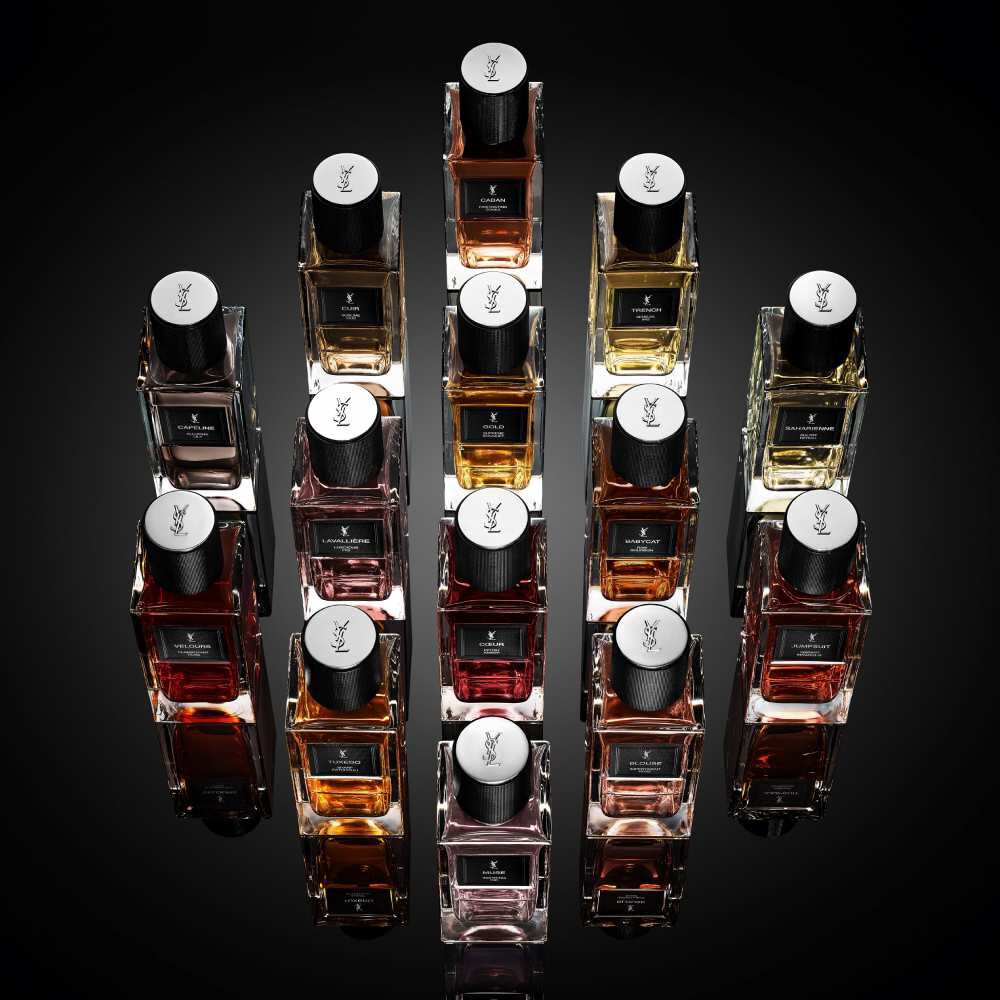 YSL-Parfumflakons in geometrischer Anordnung vor schwarzem Hintergrund