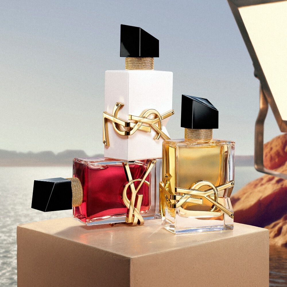 YSL-Duftflakons auf einem Podest vor einer Wustenlandschaft.