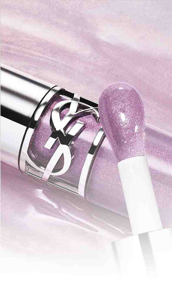 A close-up of a shiny, silver lipstick tube with a lavender metallic finish, accompanied by a lip applicator covered in a sparkly light purple gloss.