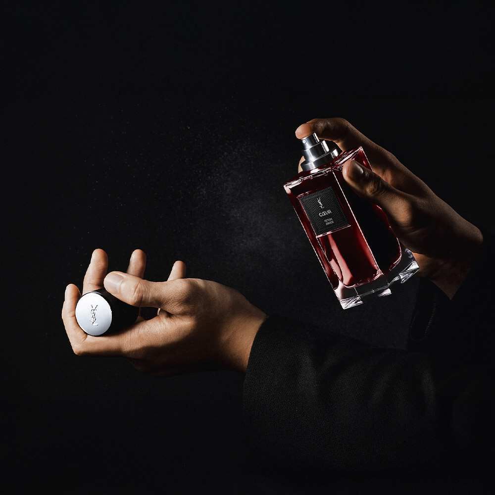 Eine Person spruht YSL „Coeur Battant“ Parfum auf ihr Handgelenk.​