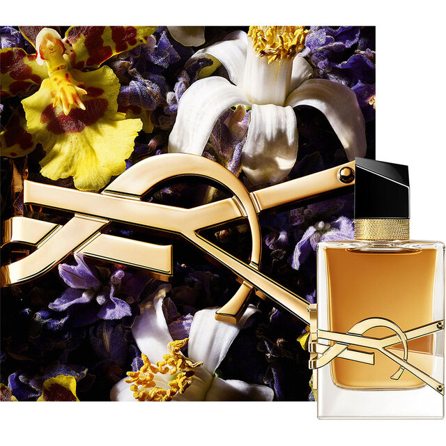 LIBRE EAU DE PARFUM INTENSE Flakon, umgeben von tiefvioletten Bluten und goldenem Kettendetail.