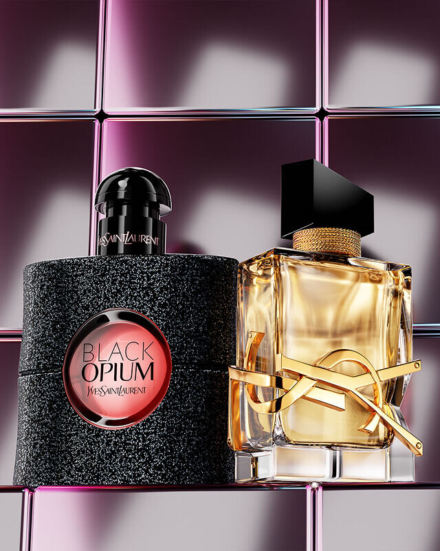 YSL Black Opium and Libre fragrances on a reflective surface with a purple tiled background.