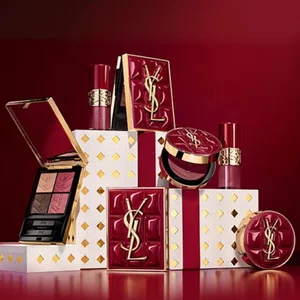 Yves Saint Laurent Weihnachtskollektion-Geschenksets und Luxus-Beautyprodukte vor festlich rotem Hintergrund.