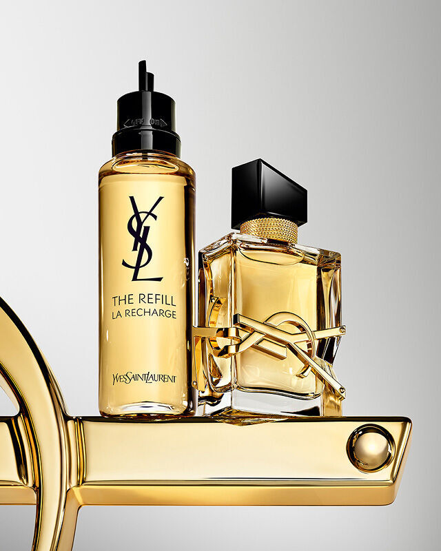 Libre Eau de Parfum Flakon und Nachfullflakon mit ubergroßem goldenen YSL-Logo.