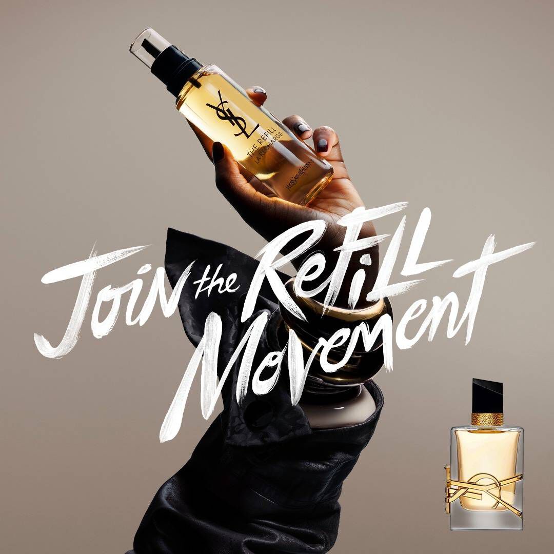 Eine Hand halt einen goldenen Refill-Flakon vor einem neutralen Hintergrund. Links steht in weißem Text im Pinselstil „Join the REFILL Movement“, und rechts ist ein klassischer YSL Libre Glasflakon mit seinem markanten goldenen Logo abgebildet.