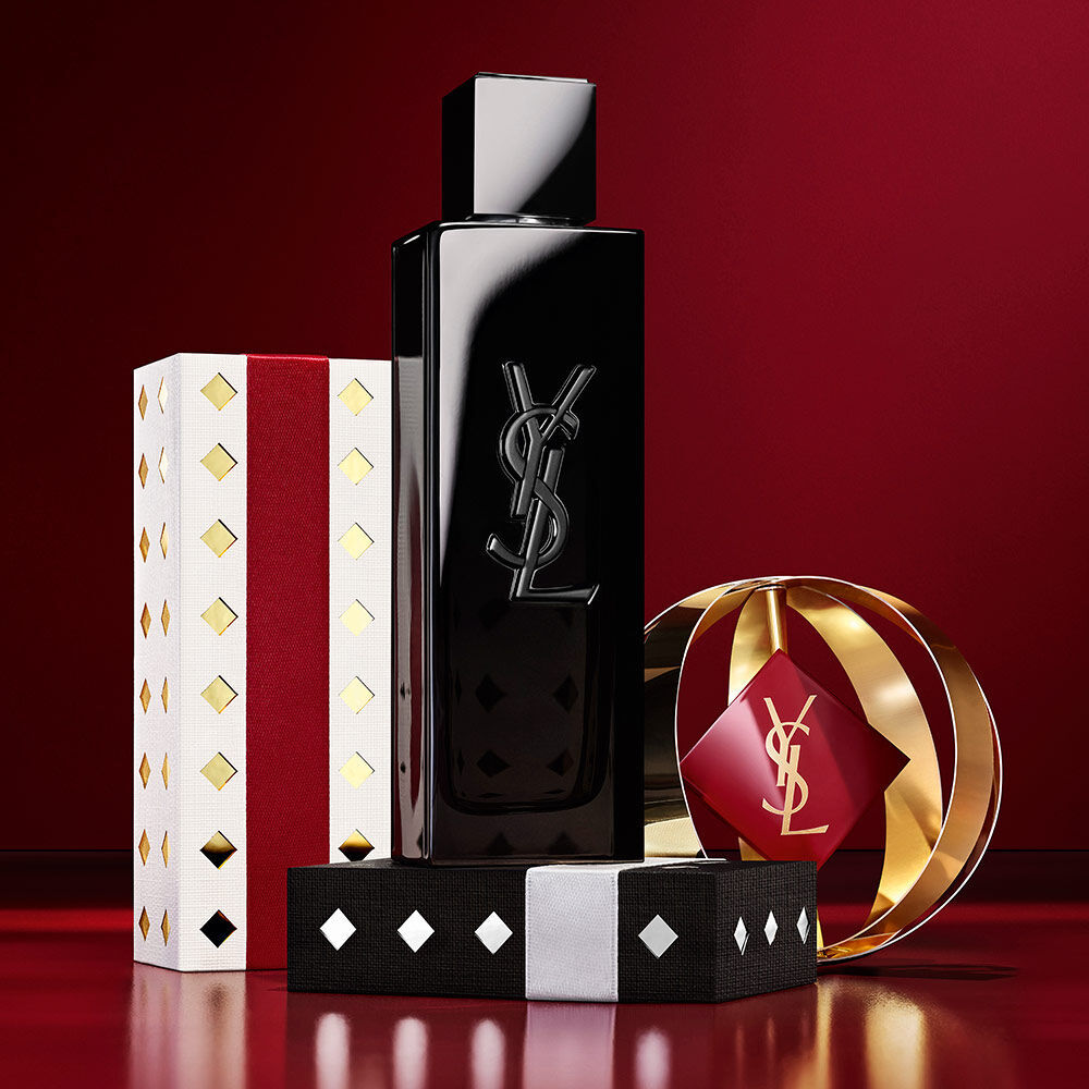 YSL MYSLF-Parfumflakon in Szene gesetzt mit goldener und burgunderroter Holiday-Geschenkverpackung.