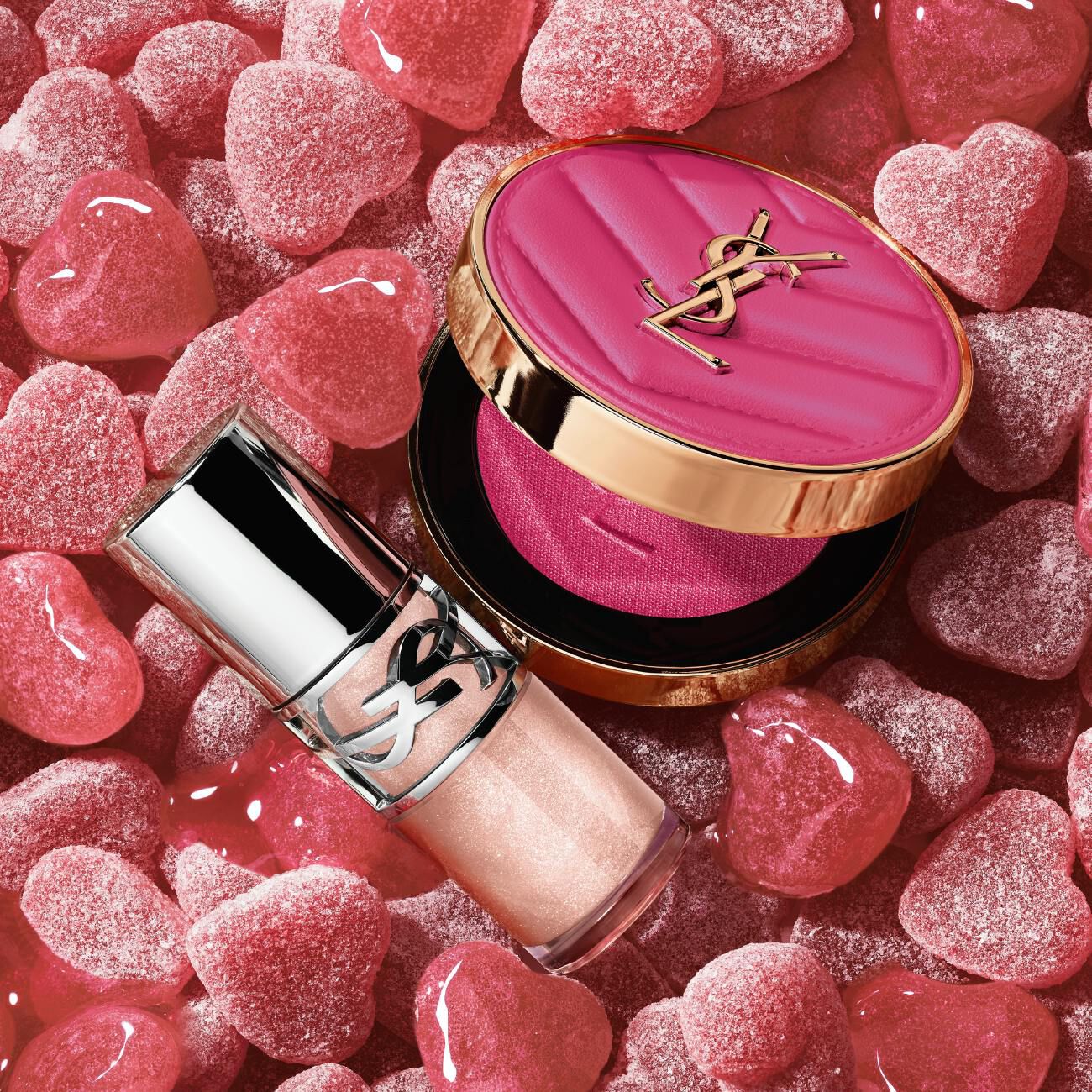 YSL Make Me Blush Powder Blush and LOVESHINE Plumping Lip Oil Gloss in shade 10, nestled among pink heart-shaped candie.