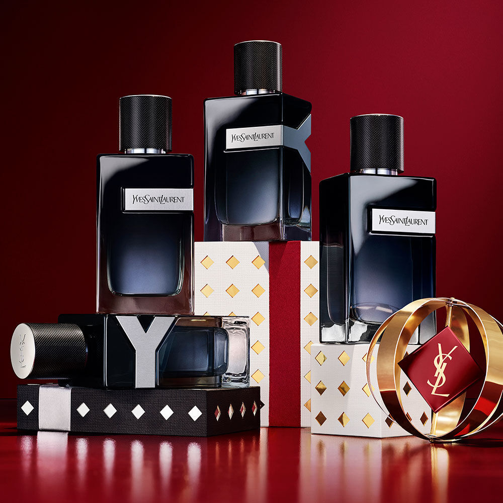 YSL Y Eau de Parfum-Flakons gestapelt auf schwarzen, weißen und goldenen Holiday-Geschenkboxen.