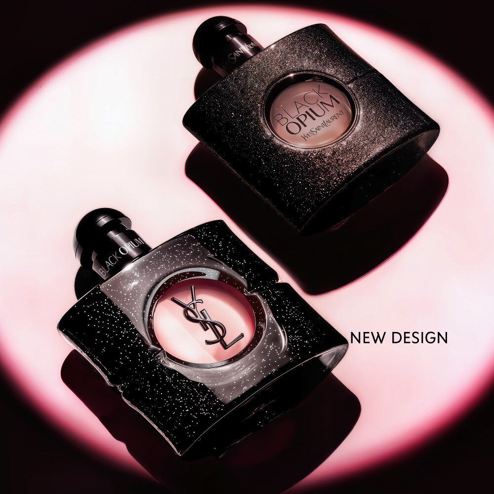 Black Opium Eau de Parfum Flakon, seitlich auf einer dunklen Oberflache liegend, umgeben von einem pinken Lichthalo.