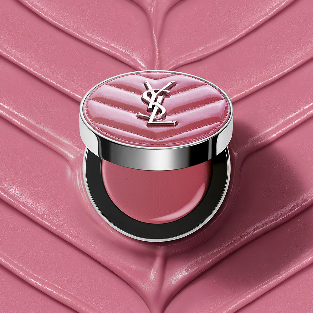 Ein offener YSL Make Me Blush Lifted Glow Cream Blush Kompakt in Nuance #44 Nude Lavalliere auf einem passenden pinken, strukturierten Creme-Hintergrund.