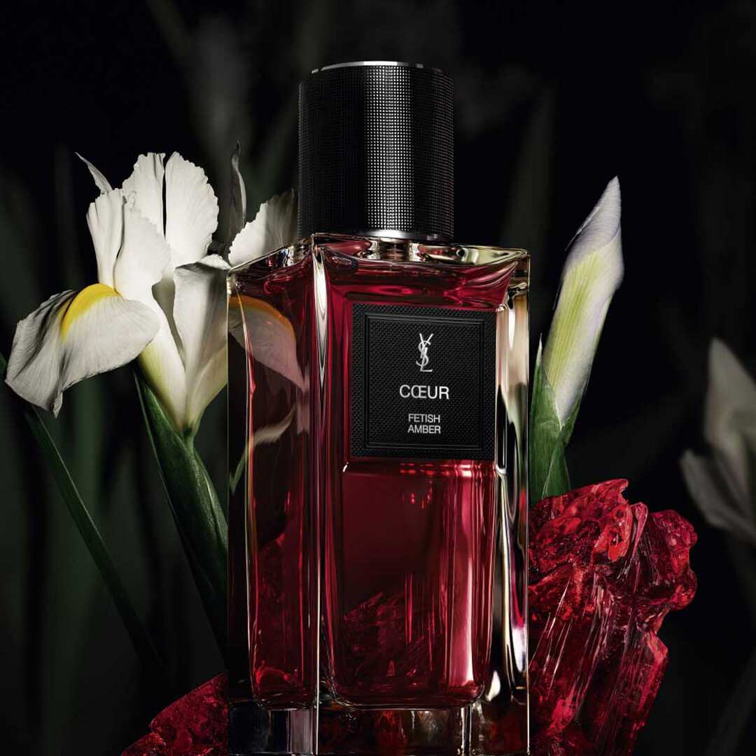 Roter YSL-Parfümflakon mit weißen Blumen.