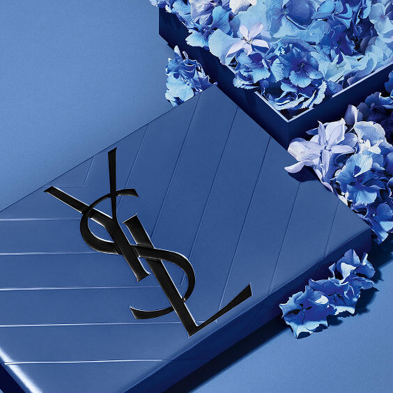Blaues YSL Vatertags-Geschenkset mit dem ikonischen Cassandre-Logo, umrahmt von zarten blauen Blütenakzenten.