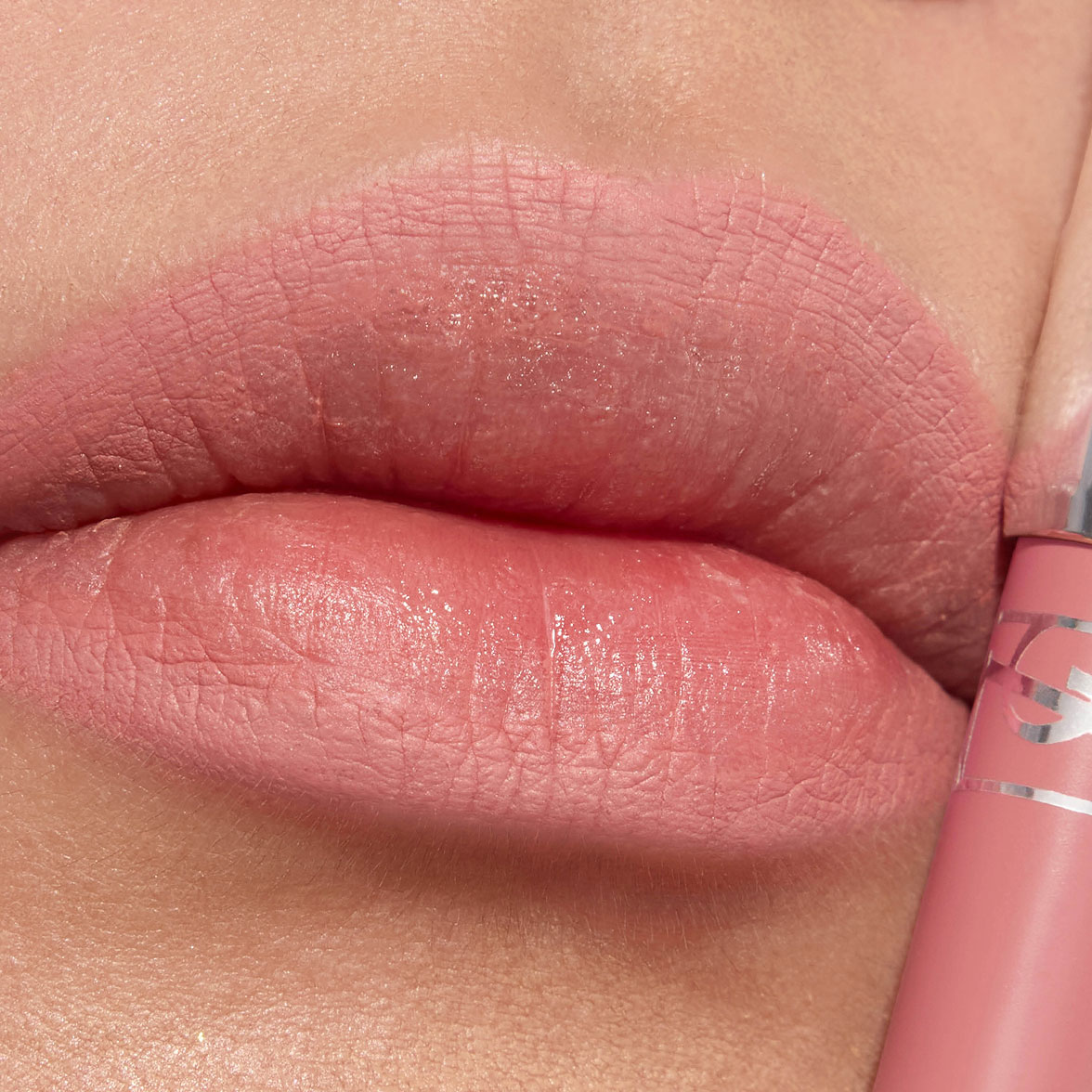 Nahaufnahme von Lippen mit einem zartrosa matten Lippenstift und passender Hülse.