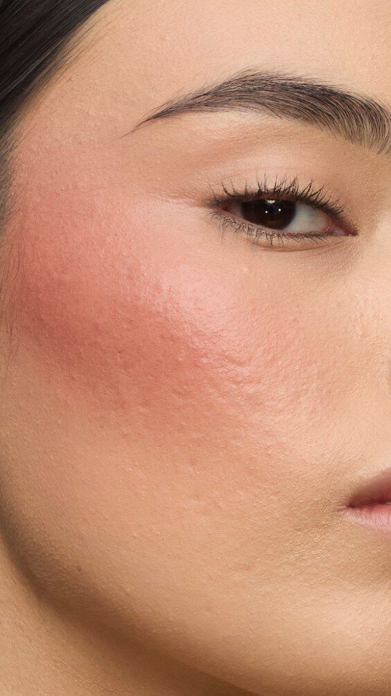Nahaufnahme einer Wange mit dem Make Me Blush-Ritual: Puder #37 Peachy Nude kombiniert mit Creme #90 Toffee Temptation für einen sonnenverwöhnten Glow.