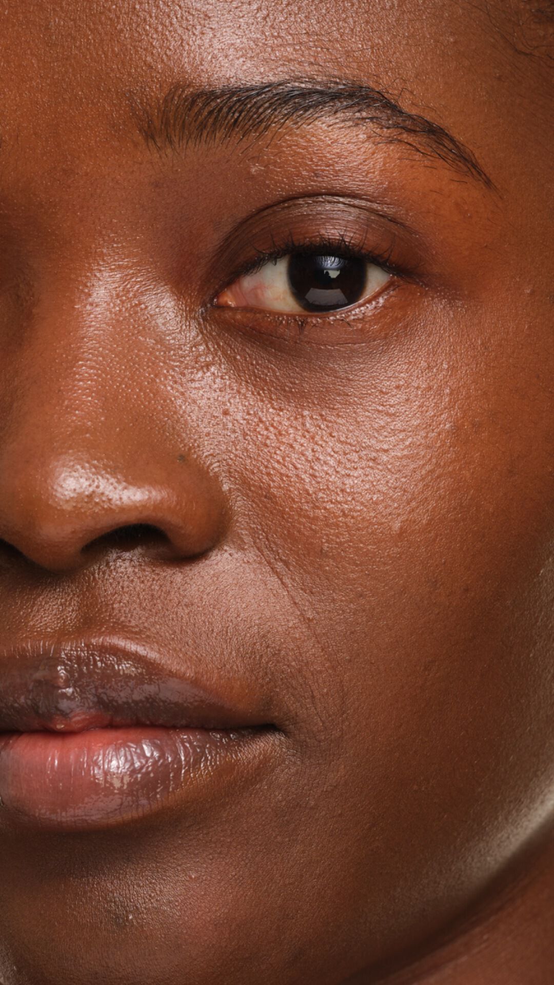YSL SKIN AFFAIR FOUNDATION auf Haut mit dunklem Hautton. Extremer Zoom auf das ebenmäßige, porenfreie und gesund wirkende Soft-Glow-Finish.