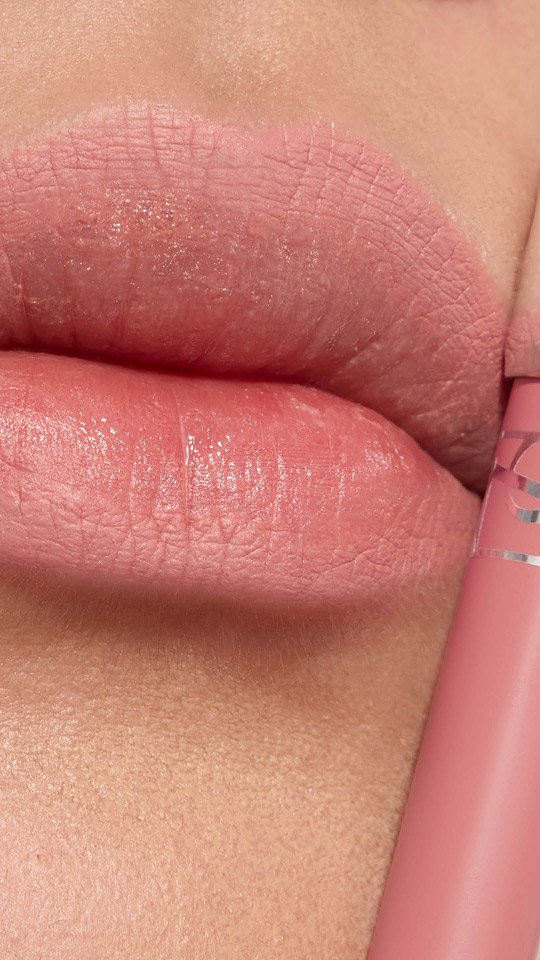 Vertikale Nahaufnahme von Lippen mit zartrosa mattem Lippenstift und passender Hülse.