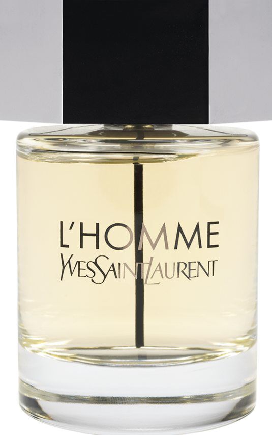 Ein Flakon des Duftes Yves Saint Laurent L'Homme mit klarem Glaskörper, hell bernsteinfarbener Flüssigkeit und einem großen silbernen sechseckigen Verschluss.
