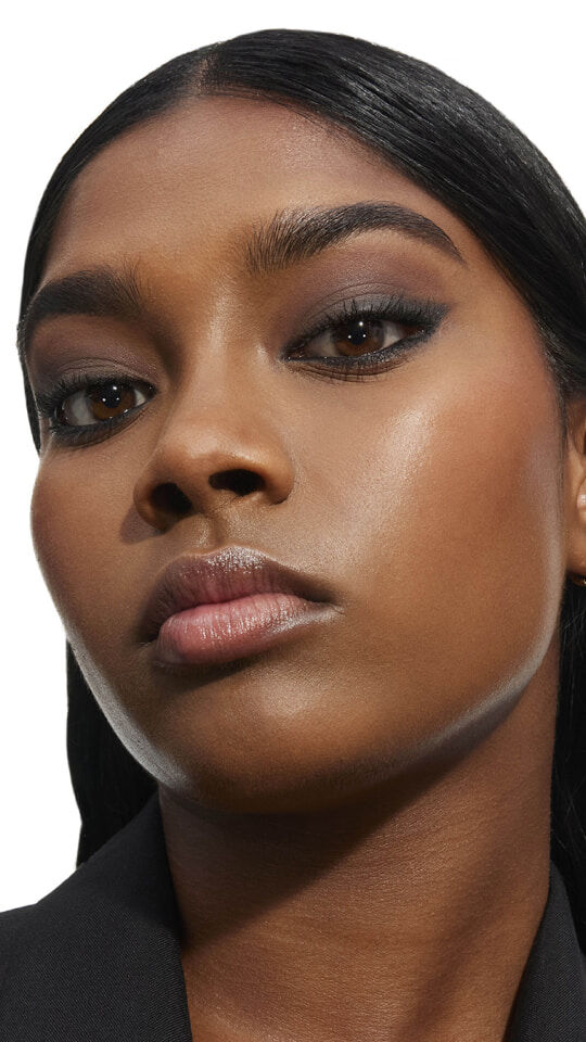 Eine Frau mit einem Smoky-Eye-Make-up-Look in tiefen Neutral- und Anthrazittönen aus der Yves Saint Laurent Palette.