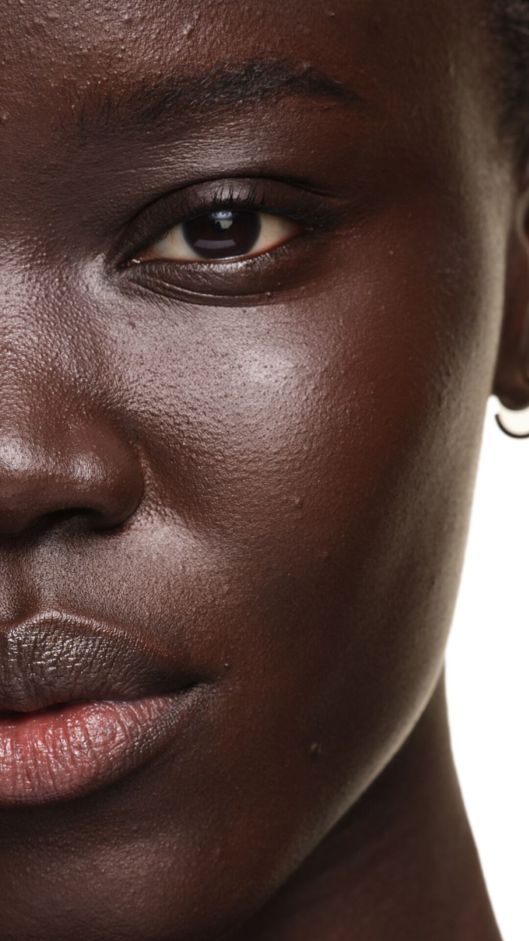 Ergebnis auf dunkler Haut mit YSL SKIN AFFAIR FOUNDATION. Nahaufnahme zeigt einen strahlenden, glatten und perfekt ebenmäßigen Teint.