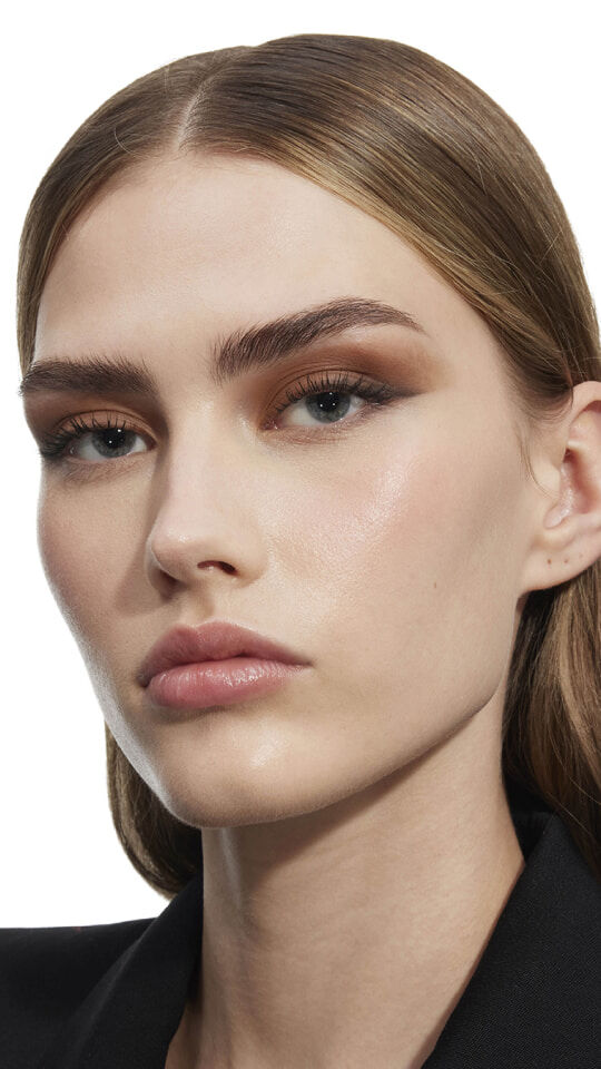 Eine Frau mit einem sanften, mattbraunen Lidschatten-Look und definierten Augenbrauen, der die natürlichen Töne der Yves Saint Laurent Palette zur Geltung bringt.