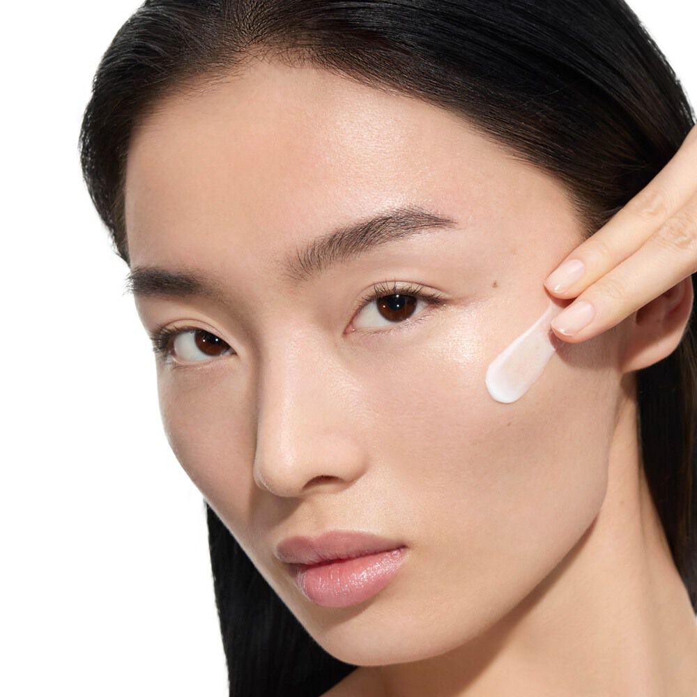Wen, YSL Beauty Model mit heller Haut, trägt YSL Beauty Pure Shots Youth Reload Cream auf ihre Wange auf.