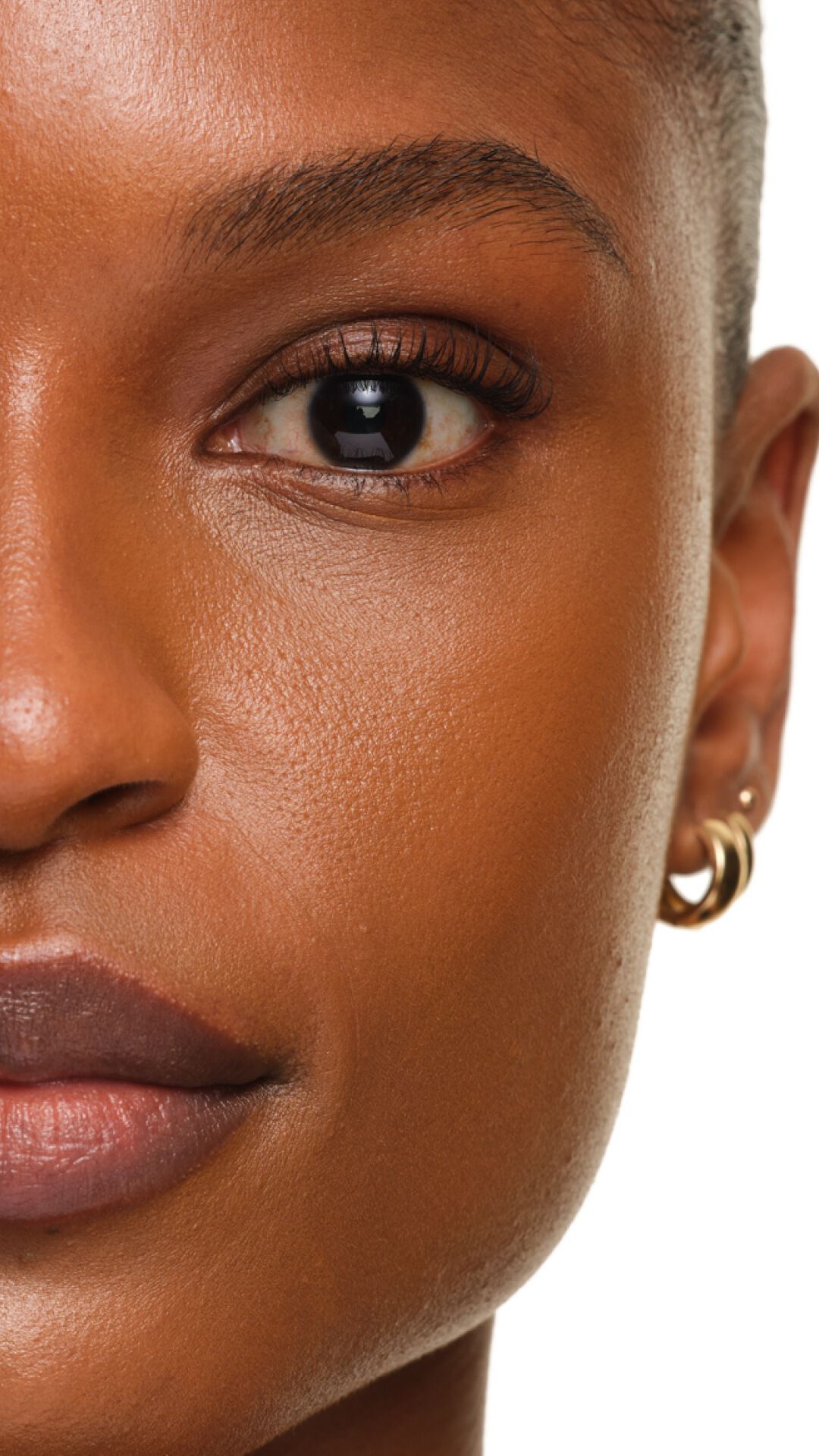 Strahlendes Finish der YSL SKIN AFFAIR FOUNDATION auf dunkler Haut. Nahaufnahme zeigt eine glatte, porenfreie und leuchtende Textur.