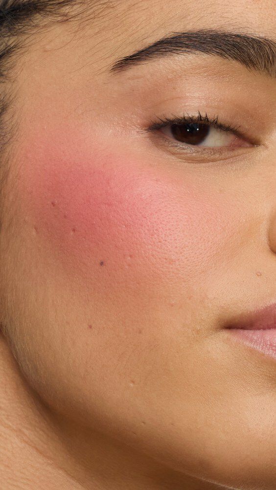 Nahaufnahme einer Wange mit dem Make Me Blush-Ritual: Puder #54 Berry Bang kombiniert mit Creme #44 Nude Lavallière für einen lebendigen, maßgeschneiderten Pink-Statement.