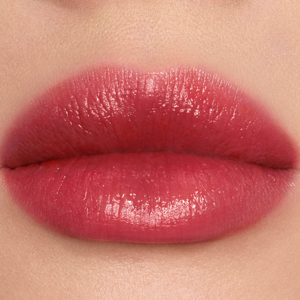 Nahaufnahmen von YSL Vinyl-Shine-Farbflecken auf den Lippen in Nuance #445 Ring Me Pink.
